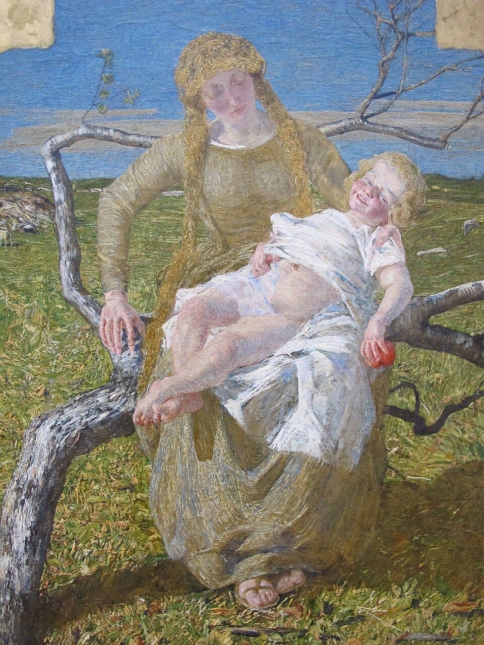 Segantini, The Fruit of Love (Il frutto dell’amore): a young mother in a golden-green dress and gold headscarf, eyes closed, sits on a bent birch branch in a green meadow cradling a smiling fair-haired child in white who holds a red apple, blue sky beyond.